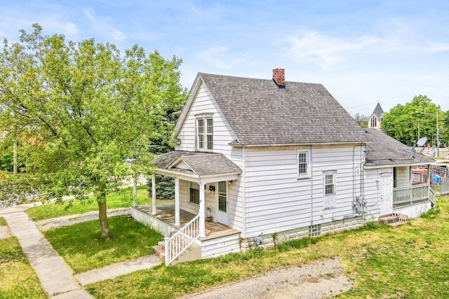 19 Stanton St, Oxford, MI 48371 - view of side of property featuring a porch, a chimney, a shingled roof, and a lawn