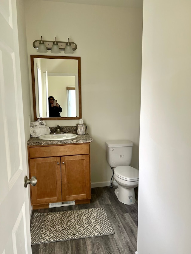 bathroom featuring hardwood / wood-style floors, vanity, and toilet