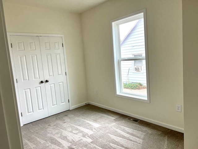 unfurnished bedroom featuring light carpet and a closet