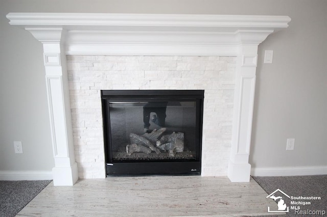 details featuring a stone fireplace and crown molding