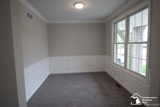 spare room with dark colored carpet and crown molding