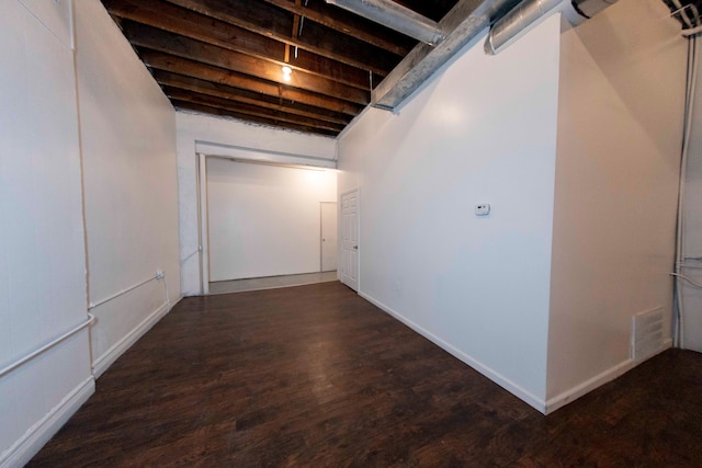 basement with dark hardwood / wood-style floors