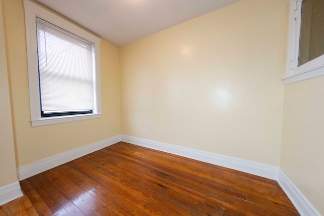 empty room with hardwood / wood-style flooring and a healthy amount of sunlight