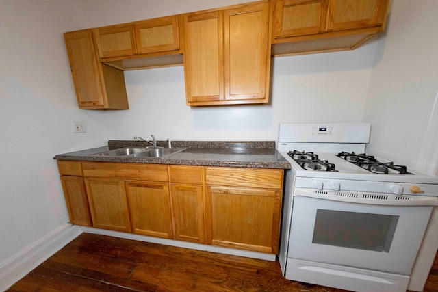 kitchen with sink, dark wood-type flooring, and white range with gas cooktop