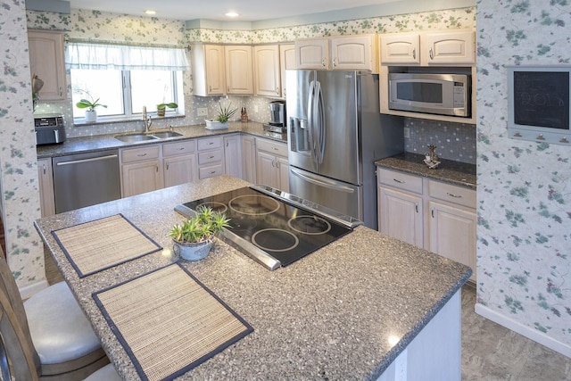 kitchen with a breakfast bar, a kitchen island, sink, and stainless steel appliances