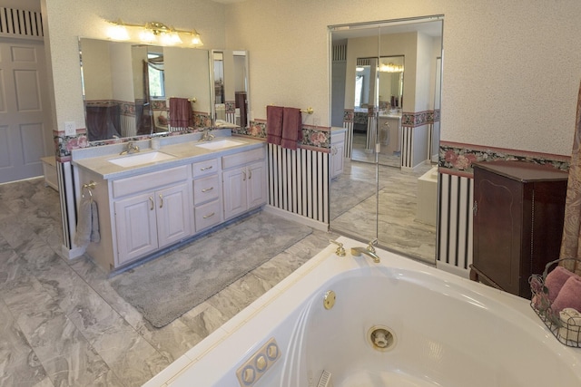 bathroom with a chandelier, vanity, and a bathing tub