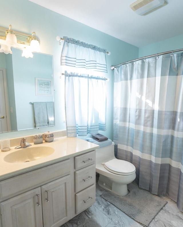 bathroom with vanity, a shower with shower curtain, and toilet