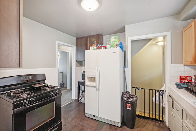 kitchen featuring decorative backsplash, gas stove, tile countertops, and white fridge with ice dispenser