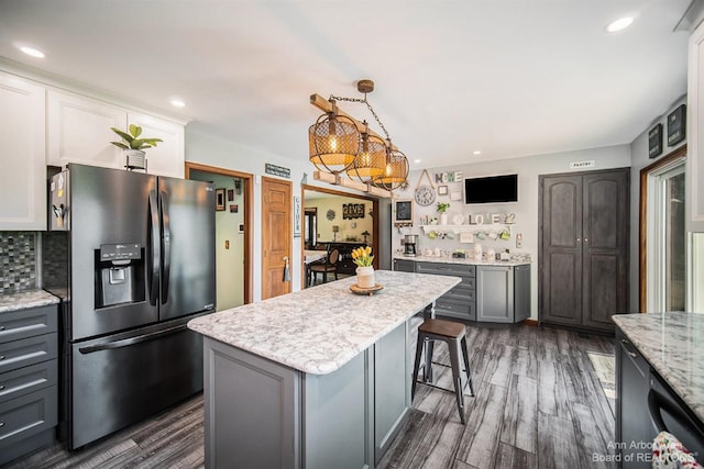 kitchen featuring gray cabinetry, decorative light fixtures, a kitchen island, dark hardwood / wood-style flooring, and stainless steel fridge with ice dispenser