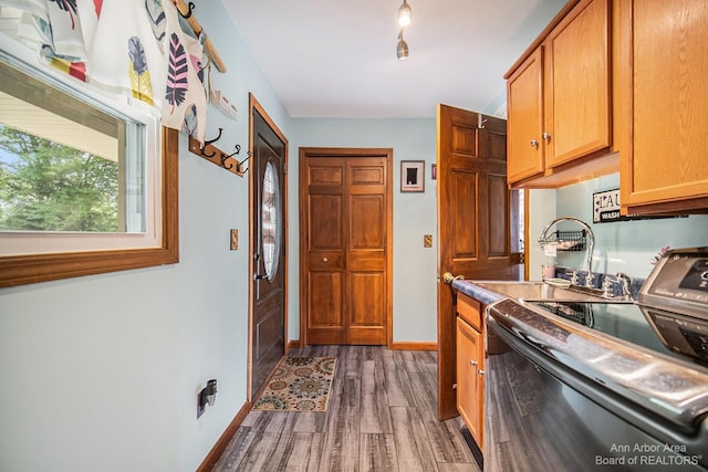 kitchen with black range with electric stovetop, dark wood-type flooring, and sink