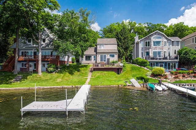 view of dock with a lawn and a water view