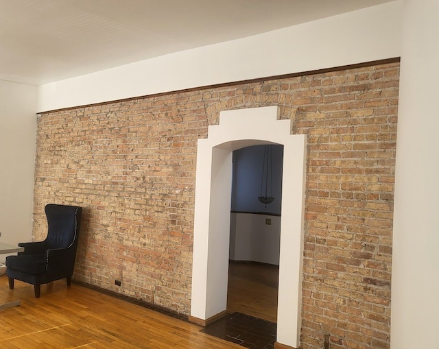 677 Selden St, Detroit, MI 48201 - corridor featuring wood finished floors, arched walkways, baseboards, and brick wall