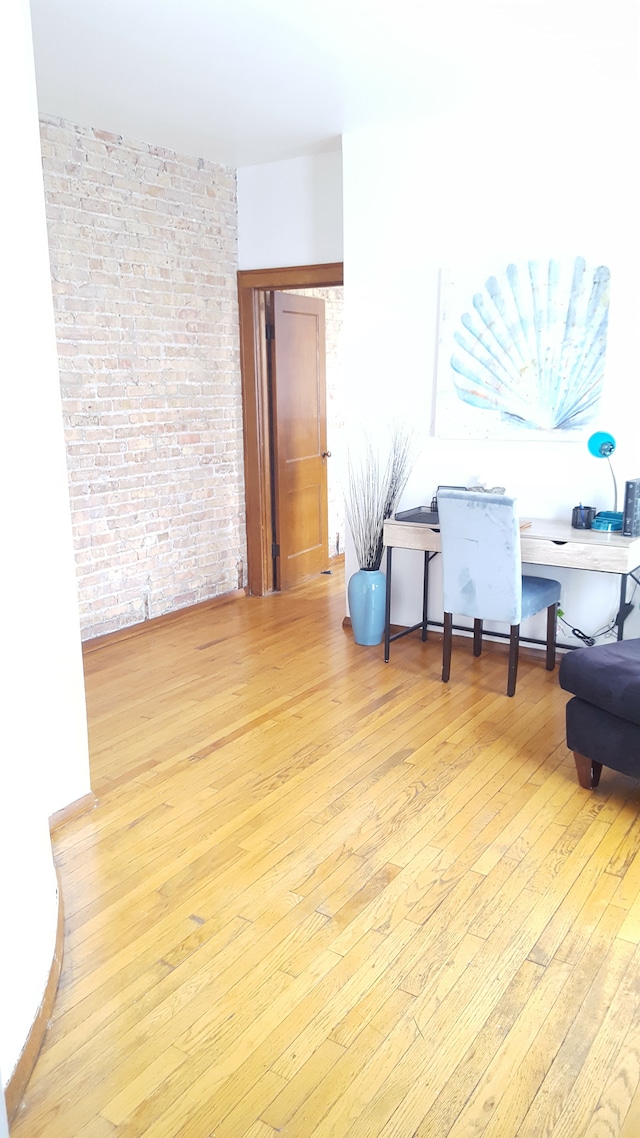 677 Selden St, Detroit, MI 48201 - living room featuring light wood-type flooring and brick wall