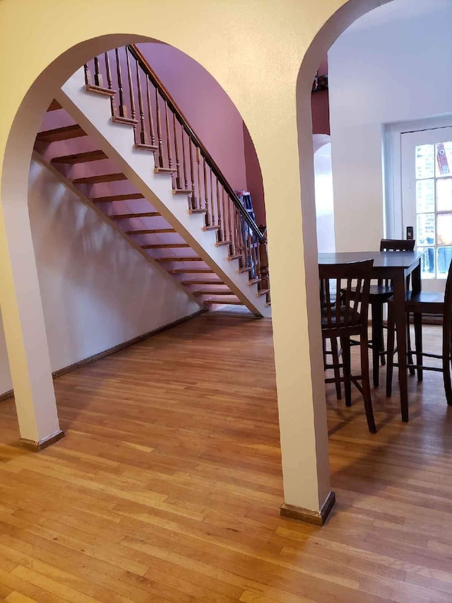 677 Selden St, Detroit, MI 48201 - staircase featuring hardwood / wood-style flooring, baseboards, and arched walkways