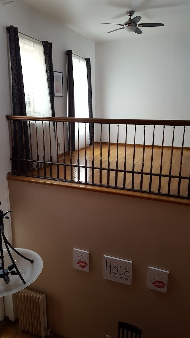 stairs featuring ceiling fan, radiator, and a wealth of natural light