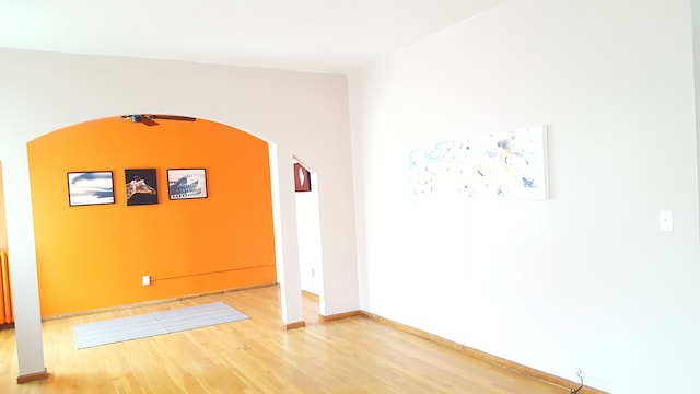 677 Selden St, Detroit, MI 48201 - empty room featuring wood finished floors, arched walkways, and baseboards