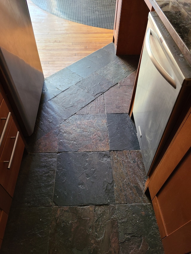 details featuring dark hardwood / wood-style flooring and stainless steel dishwasher