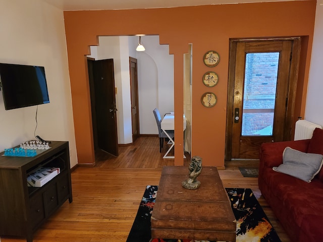 living room featuring radiator heating unit and light wood-type flooring