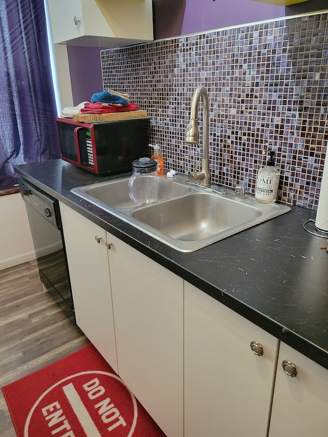 677 Selden St, Detroit, MI 48201 - kitchen with a sink, black dishwasher, white cabinetry, decorative backsplash, and dark countertops