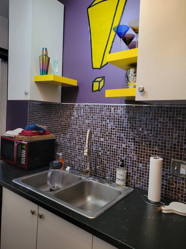 kitchen with white cabinets, backsplash, and sink