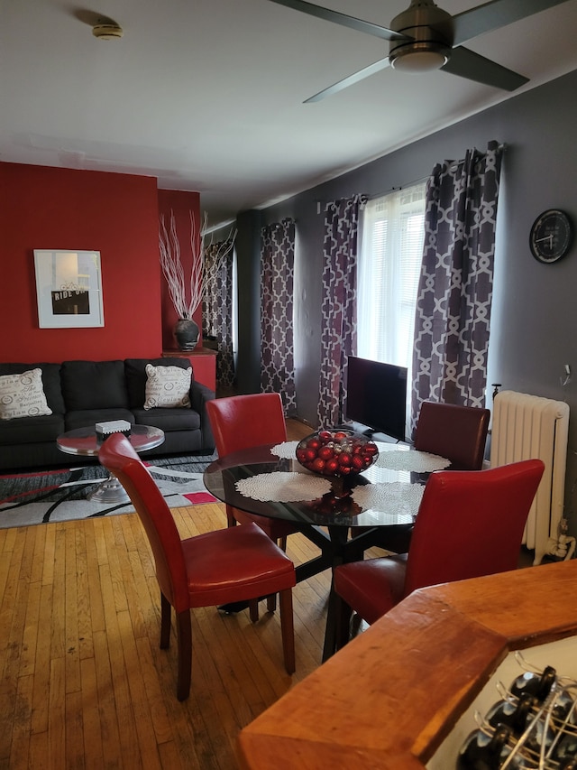 dining area featuring radiator heating unit, ceiling fan, and wood-type flooring