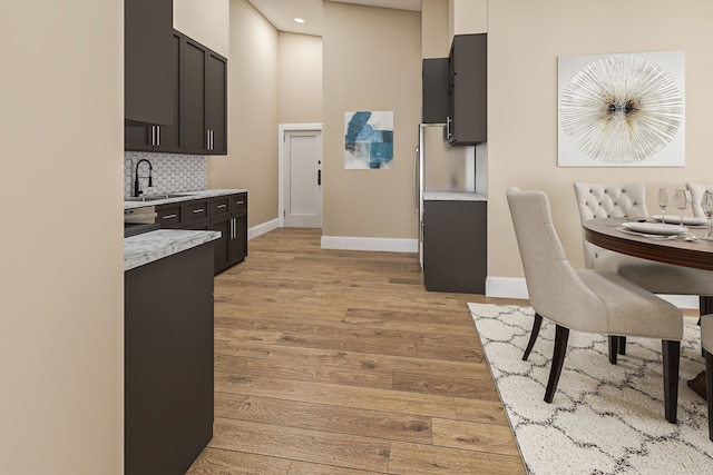 kitchen with sink, decorative backsplash, and light hardwood / wood-style floors