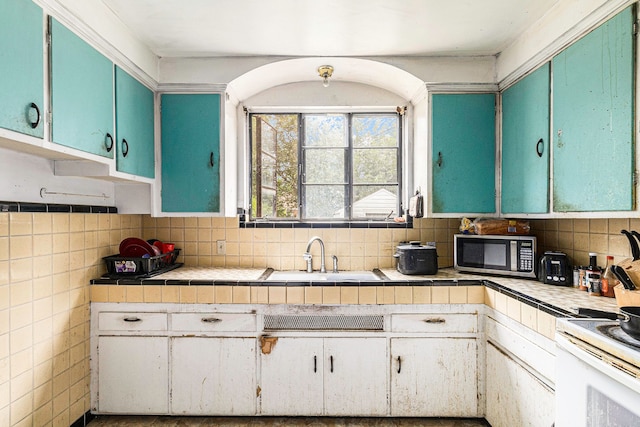 kitchen featuring backsplash, white cabinetry, and sink