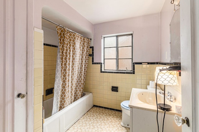 full bathroom featuring shower / bath combination with curtain, toilet, tile walls, and vanity