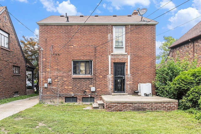 rear view of property featuring a lawn