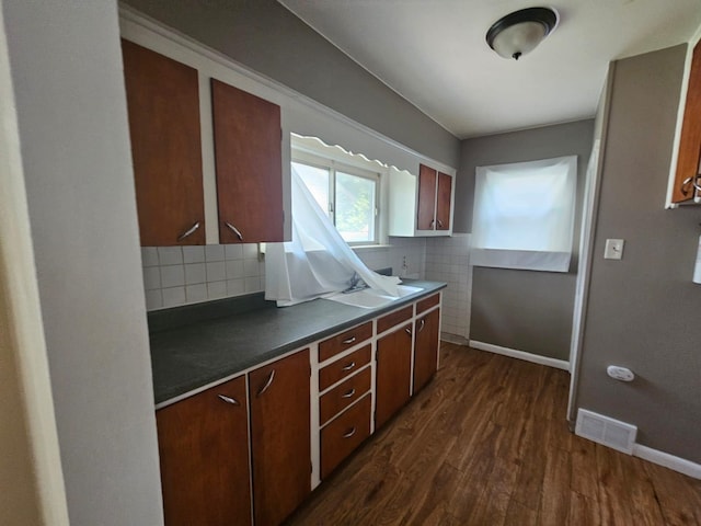 kitchen with dark hardwood / wood-style flooring and tasteful backsplash