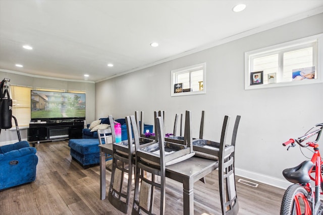 dining area featuring hardwood / wood-style flooring and ornamental molding