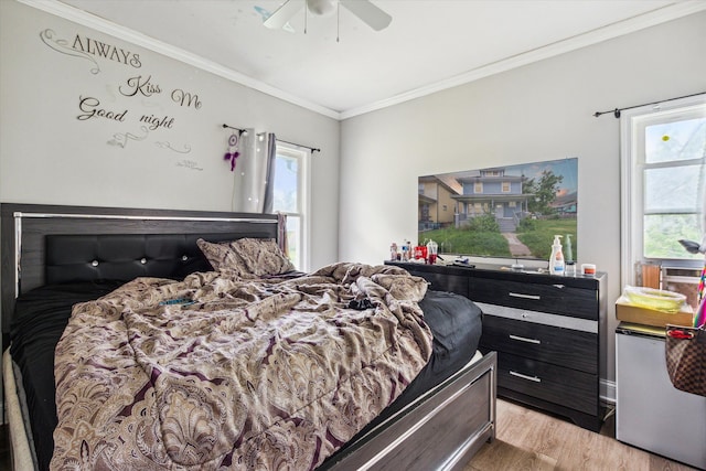 bedroom featuring light wood-type flooring, ceiling fan, and ornamental molding