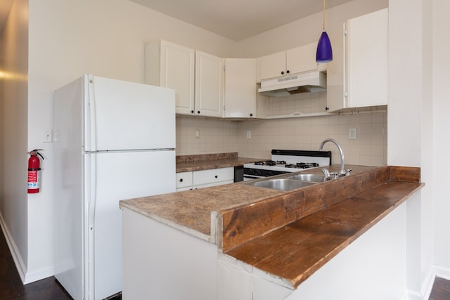 kitchen with white cabinets, white appliances, hanging light fixtures, and tasteful backsplash