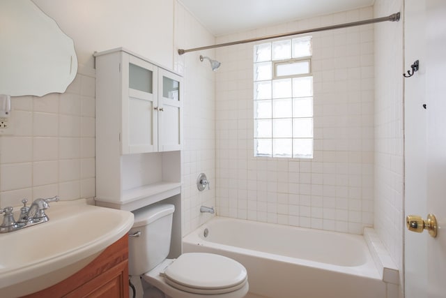 full bathroom featuring vanity, tiled shower / bath, and toilet