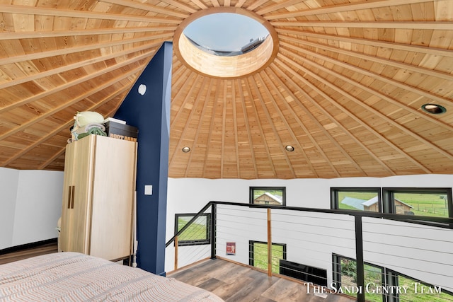 unfurnished bedroom featuring hardwood / wood-style floors, vaulted ceiling with beams, and wooden ceiling