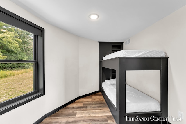 unfurnished bedroom featuring wood-type flooring and multiple windows