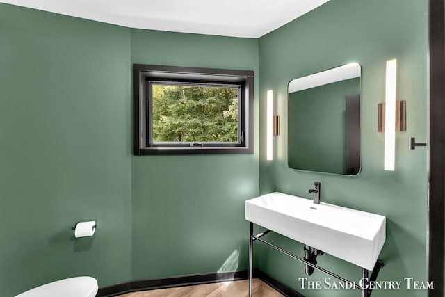 bathroom with hardwood / wood-style floors, toilet, and sink