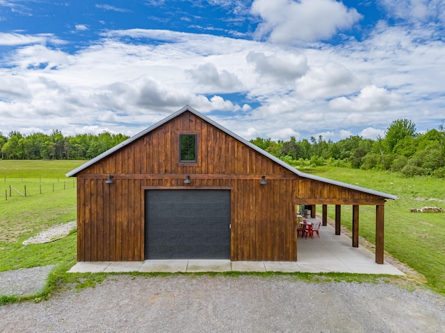 garage featuring a yard and a rural view