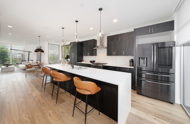 kitchen with a breakfast bar, an island with sink, stainless steel appliances, and sink