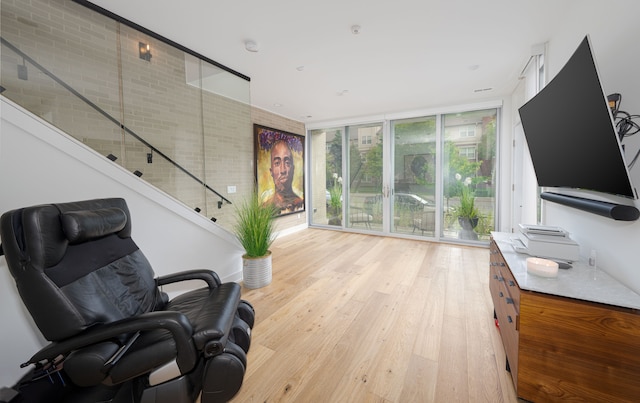 2813 Brush St Unit 99, Detroit, MI 48201 - living area featuring light wood-style flooring, expansive windows, and stairs