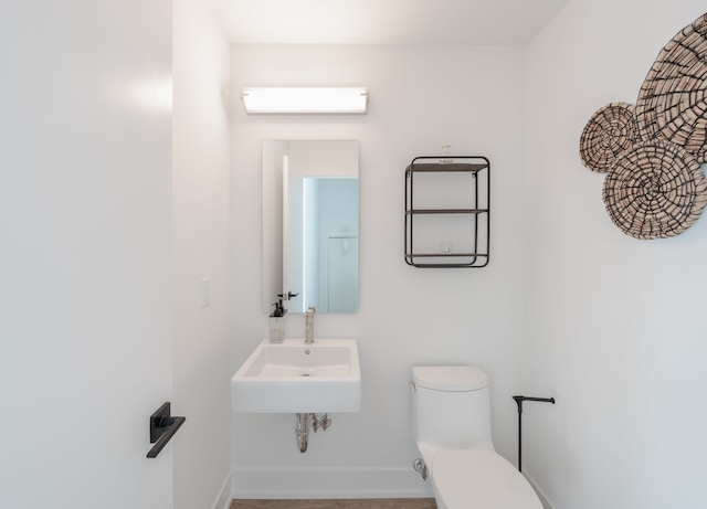 bathroom with a wall mounted AC, sink, and toilet