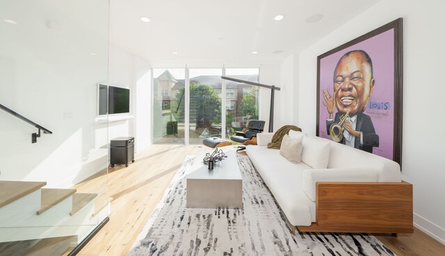 2813 Brush St Unit 99, Detroit, MI 48201 - living room featuring wood finished floors, a wall of windows, recessed lighting, baseboards, and stairway