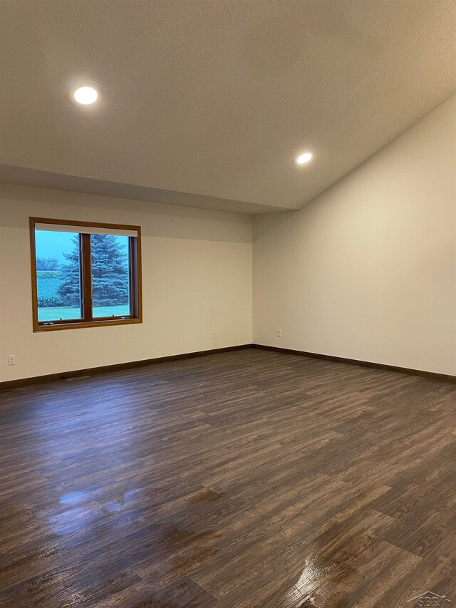 unfurnished room featuring dark hardwood / wood-style floors and a textured ceiling