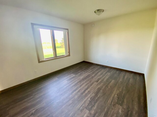 spare room featuring dark wood-type flooring