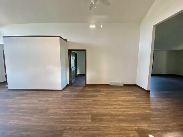 spare room with ceiling fan, dark wood-type flooring, and lofted ceiling