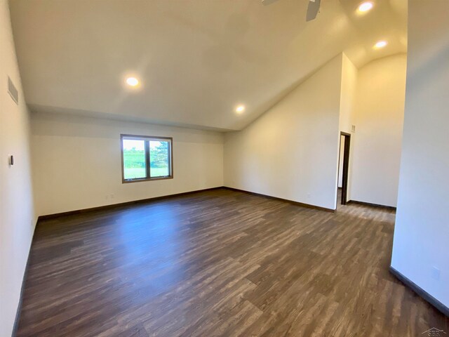 spare room with ceiling fan, lofted ceiling, and dark wood-type flooring