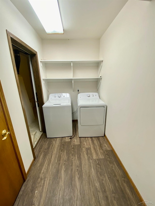 clothes washing area with dark hardwood / wood-style flooring and separate washer and dryer