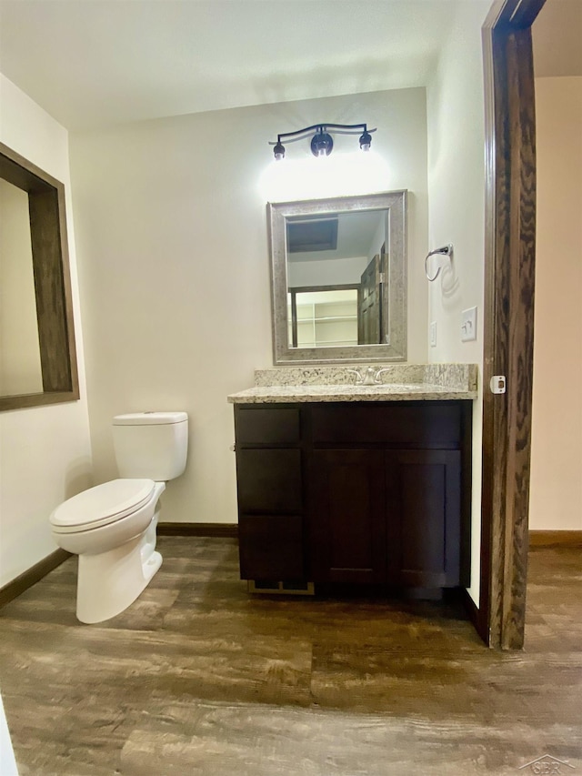 3879 Kochville Rd, Saginaw, MI 48604 - bathroom featuring wood finished floors, toilet, baseboards, and vanity