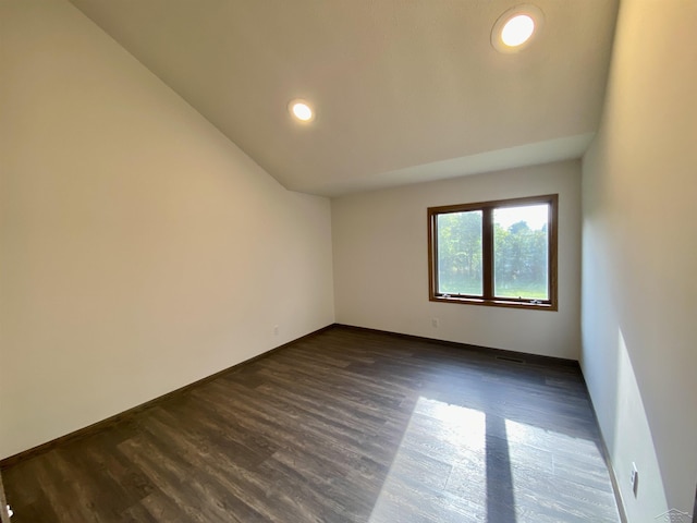 3879 Kochville Rd, Saginaw, MI 48604 - spare room featuring dark wood-style flooring, vaulted ceiling, baseboards, and recessed lighting