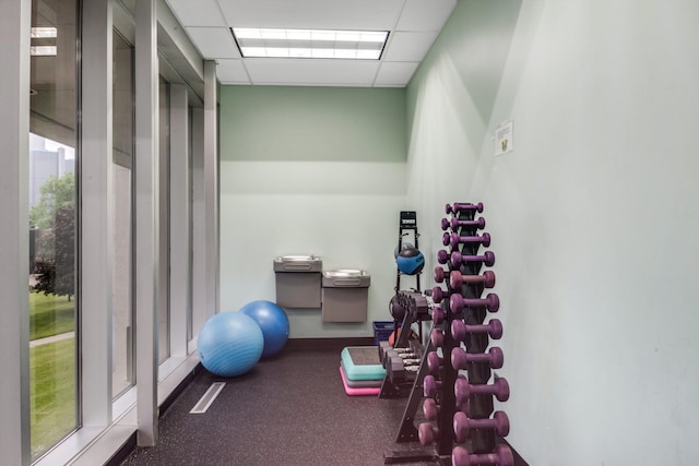 gym with dark carpet and a drop ceiling